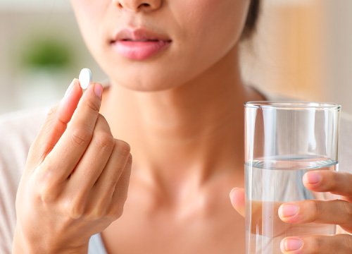 Девушка собирается принимать таблетку